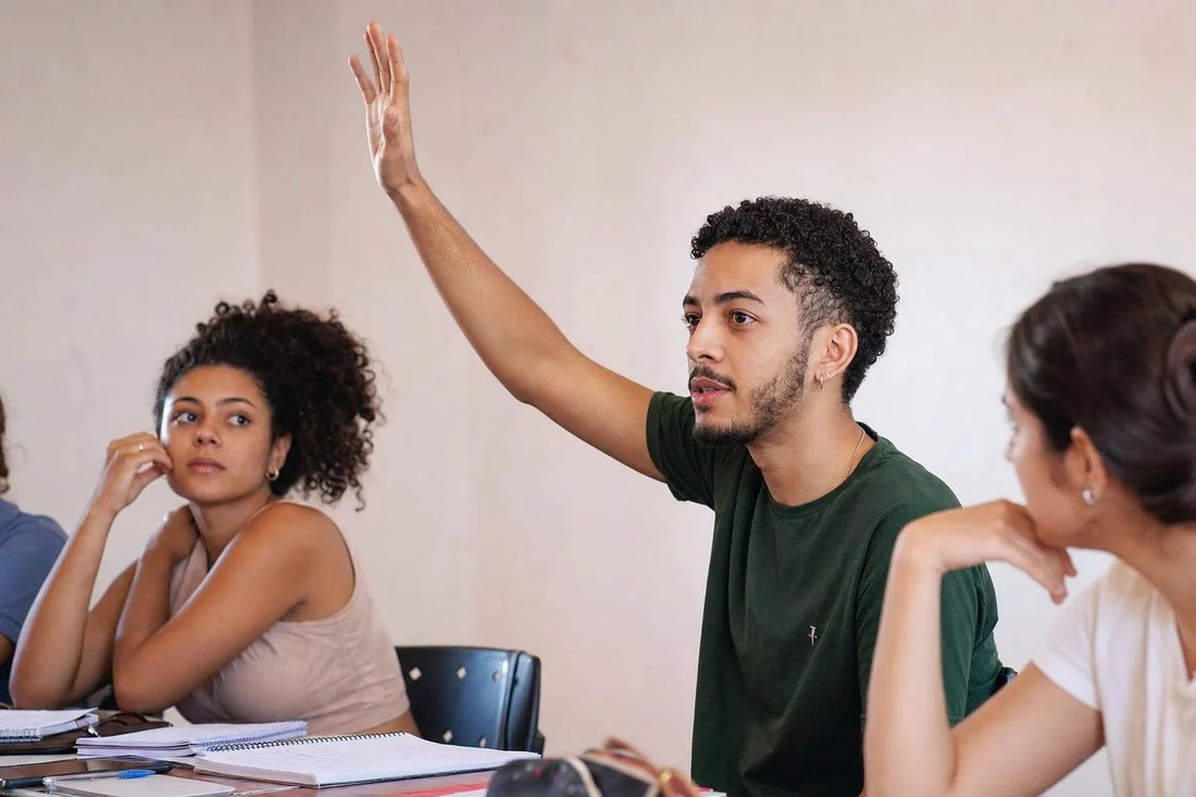 Facilitador em pé apontando para um argumento escrito no quadro durante a sessão